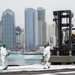 Civilian personnel place pallets on the flight deck of USS Carl Vinson(CVN70)
