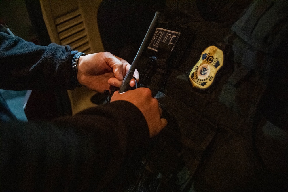 An ICE Enforcement and Removal Operations deportation officer prepares his protective equipment prior to conducting an arrest