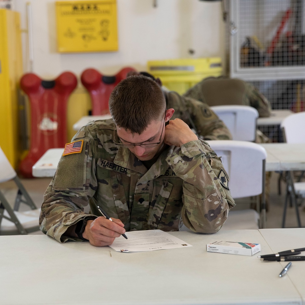 Competitors take a break from physical activities to complete the exam during SETAF-AF Best Warrior and Squad Competition