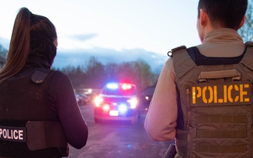 ICE Enforcement and Removal Operations (ERO) deportation officers advise a spouse that her husband has been arrested while other officers provide perimeter security