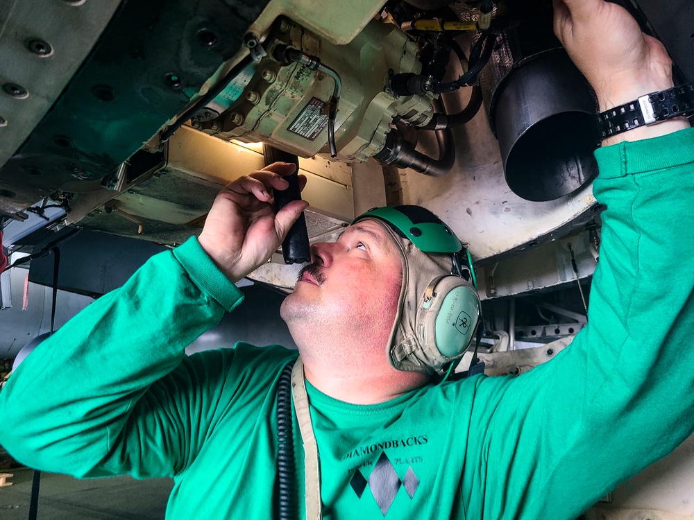 VFA-102 Sailors preform maintenance on an F/A-18E in USS Ronald Reagan (CVN 76) hangar bay