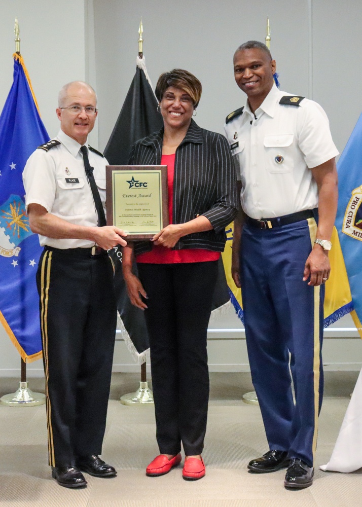 Lieutenant General Ronald J. Place and Command Sgt. Maj. Michael L. Gragg presenting an award with Ms. Janet Wilson.