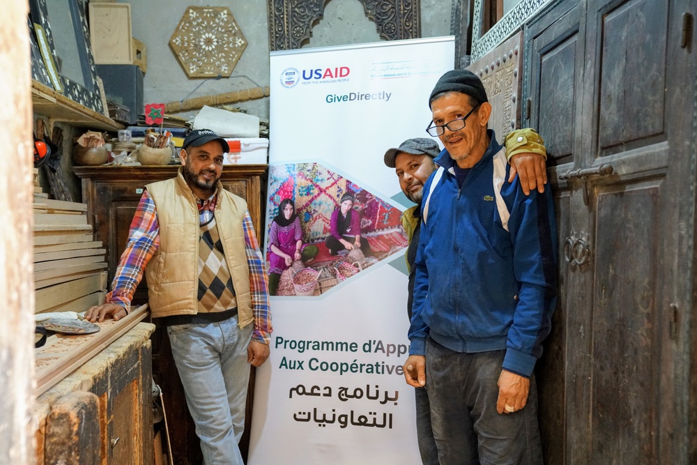 Adil Jebrane, Abedlatif Abouraji, Abderrahim Assim stand in their woodworking cooperative shop in Marrakech, Morocco