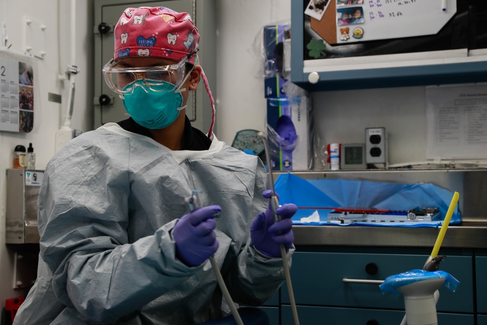 Abraham Lincoln Hospital Corpsman conducts a dental procedure