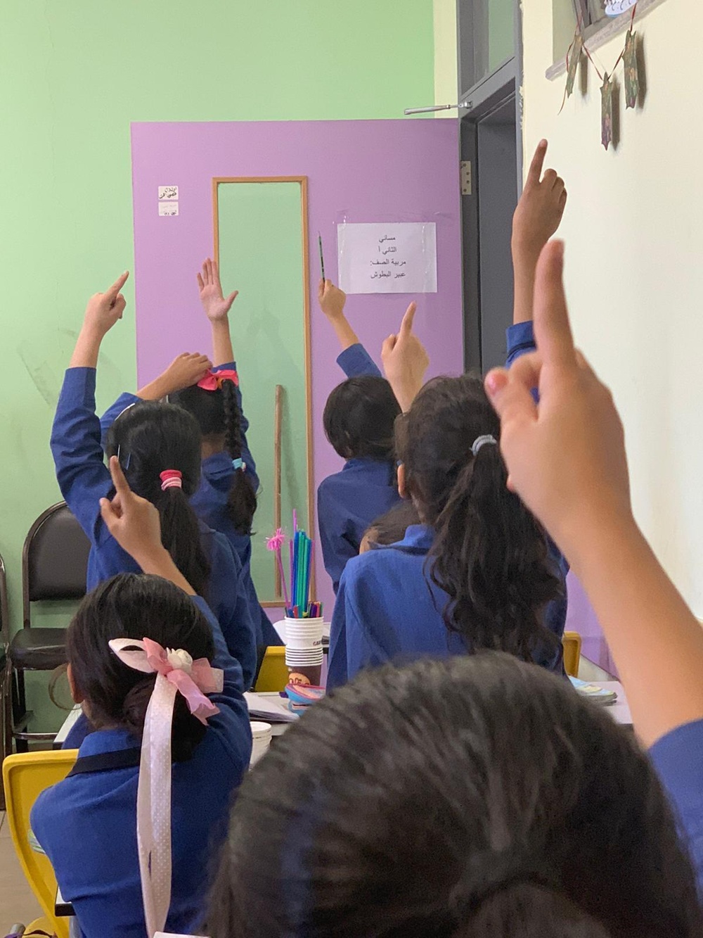 Yemeni students raise their hands in a classroom during a study tour to Jordan