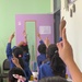 Yemeni students raise their hands in a classroom during a study tour to Jordan