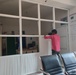 Worker installs aluminum partitions to provide privacy for reproductive health rooms at Makhran Health Center in Yemen