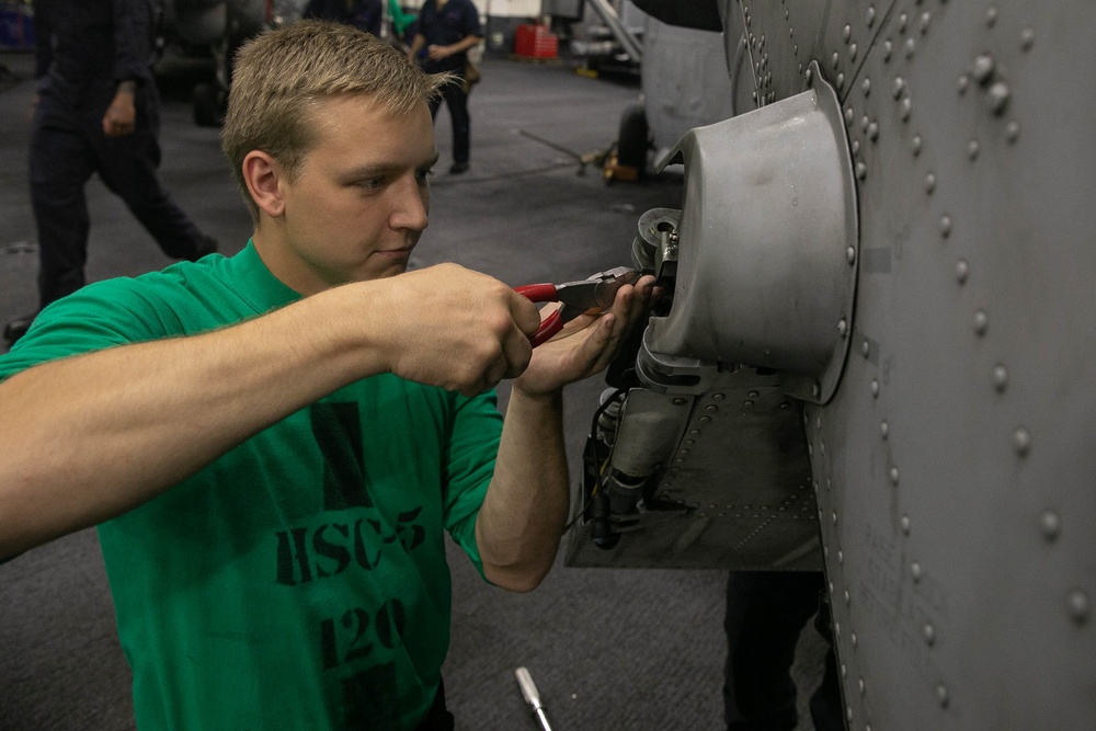 USS George H.W. Bush Sailor Installs Equipment