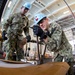 Aviation Electronics Technicians secures materials with bands in the hangar bay of Nimitz-class aircraft carrier USS Carl Vinson