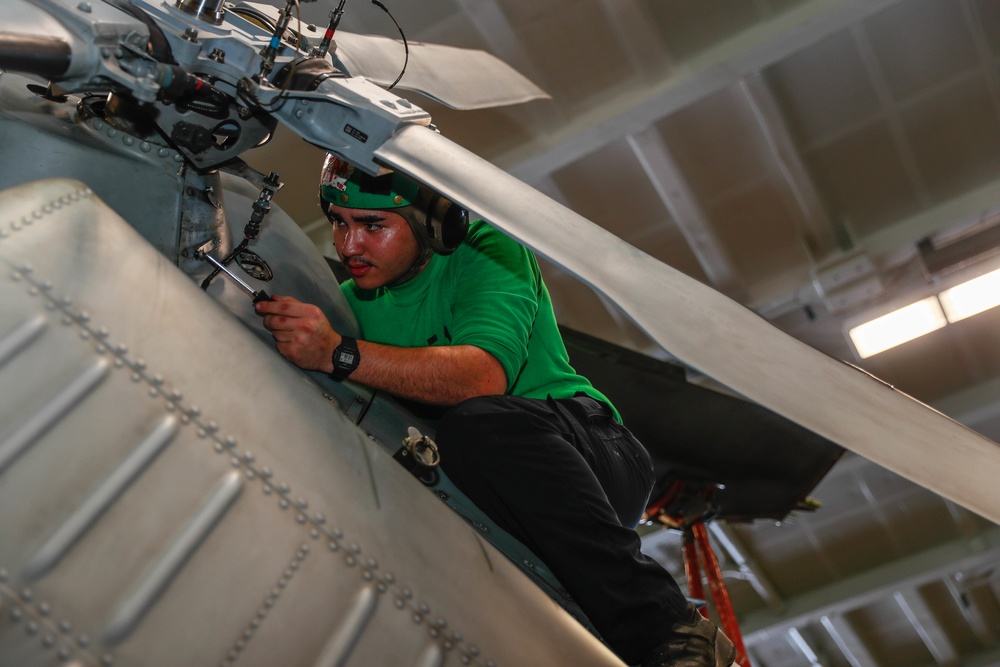 Abraham Lincoln Sailor conducts aircraft maintenance