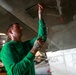 Abraham Lincoln Sailor conducts aircraft maintenance