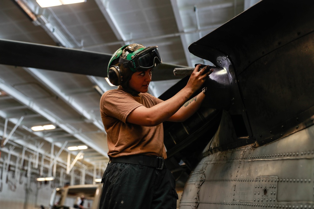 Abraham Lincoln Sailor conducts aircraft maintenance