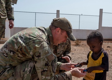 U.S. Airmen and Soldiers provide personal care items and build a swing set at Chabelley Village, Djibouti