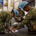 Sailors perform maintenance in the hangar bay of USS Carl Vinson (CVN 70)