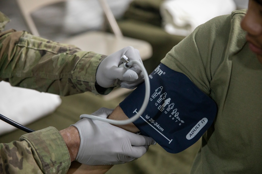 Soldier checks vital signs during Global Medic