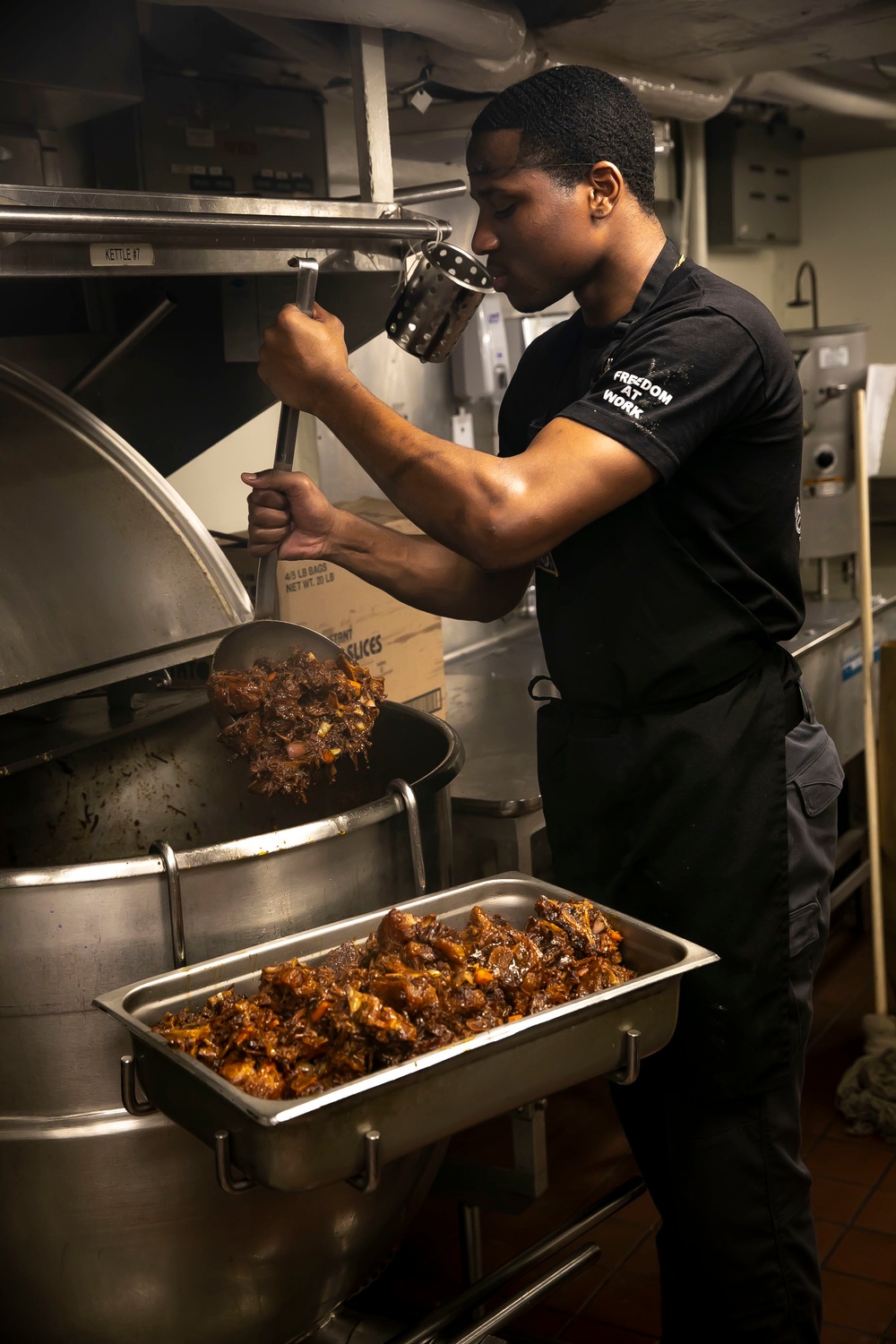 USS George H.W. Bush (CVN 77) Sailor Prepares Food