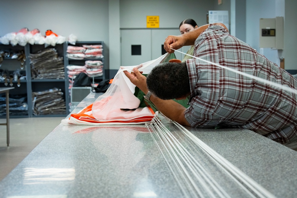 1 SOSS aircrew flight equipment specialists pack life-saving parachutes