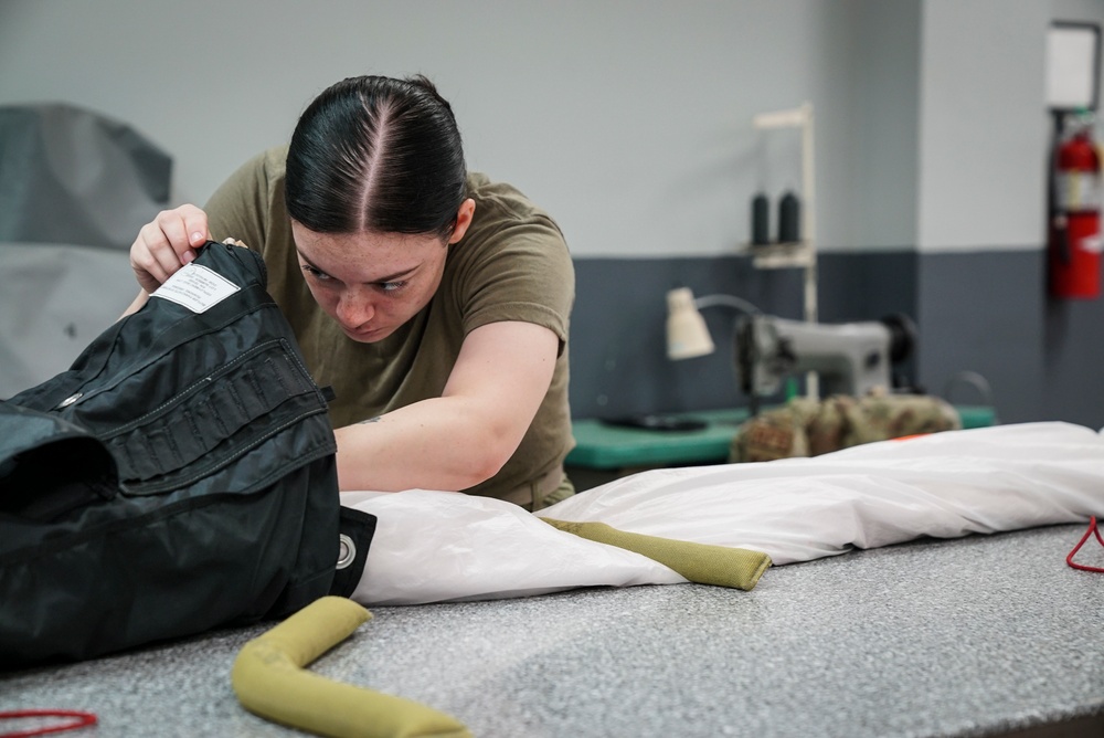 1 SOSS aircrew flight equipment specialists pack life-saving parachutes