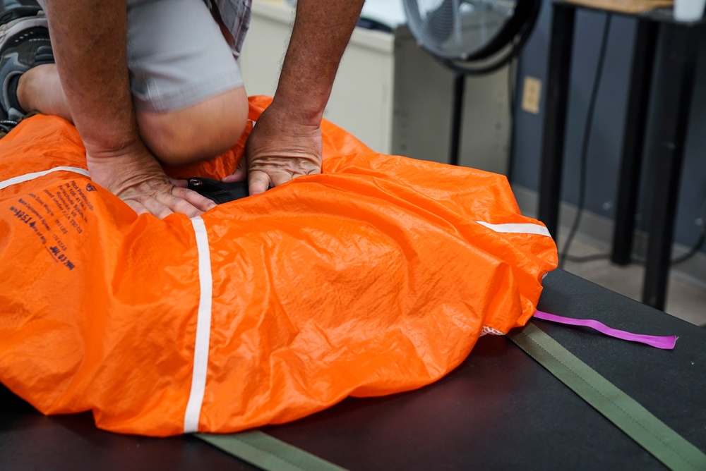 1 SOSS aircrew flight equipment specialists pack life-saving parachutes