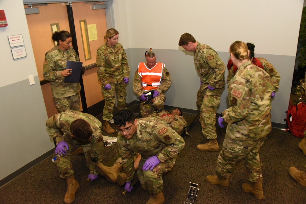 Airmen prepare to lift simulated gunshot victim in a litter