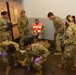 Airmen prepare to lift simulated gunshot victim in a litter