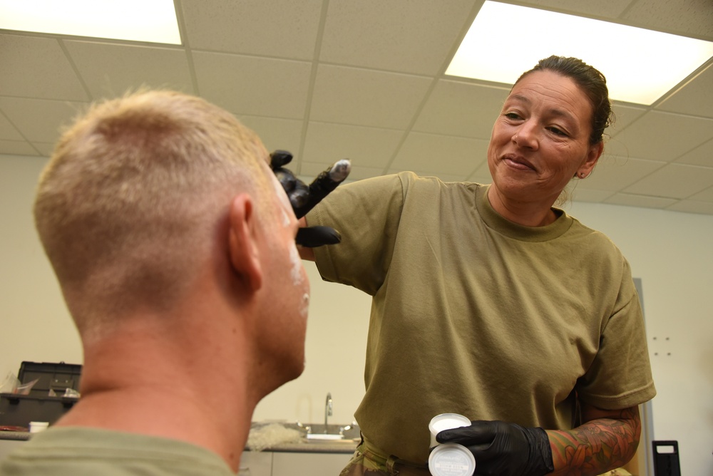 Sanchez applies makeup to an Airman