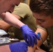 Airman watches IV application