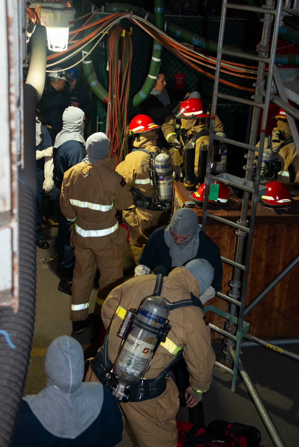 Sailors dress out in firefighting equipment