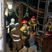 Sailors dress out in firefighting equipment