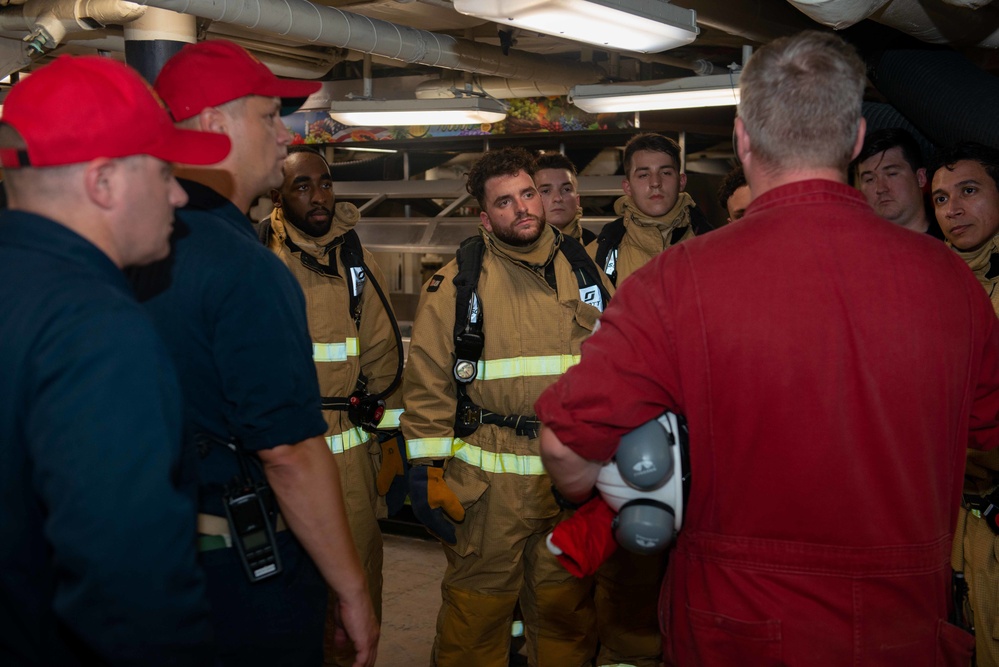 Sailors debrief after a damage control drill