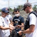 A USS Sampson Sailor and a JS Izumo Sailors exchange patches after a softball game during RIMPAC 2022