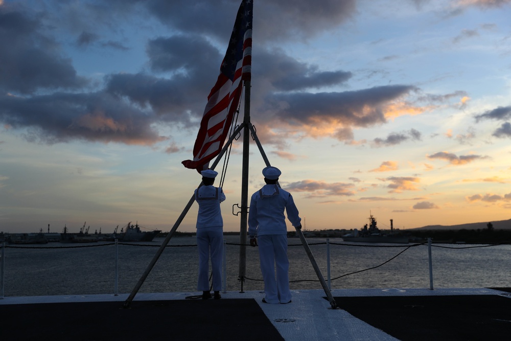 Sailors from Abraham Lincoln lower the national ensign during RIMPAC 2022