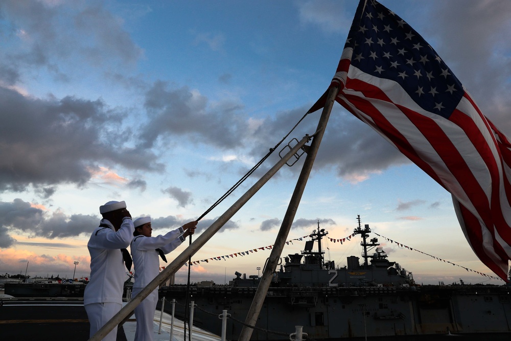 Sailors from Abraham Lincoln lower the national ensign during RIMPAC 2022