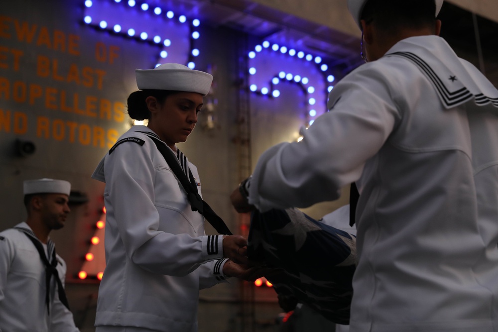Sailors from Abraham Lincoln lower the national ensign during RIMPAC 2022