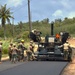NMCB THREE Seabees operate a paver to lay down asphalt on the Marpo Heights road project in Tinian.