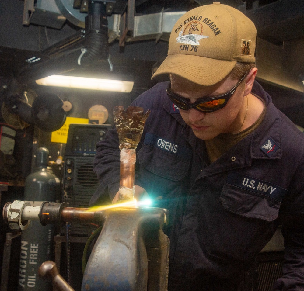 USS Ronald Reagan (CVN 76) Sailors braze pipes in the machine shop