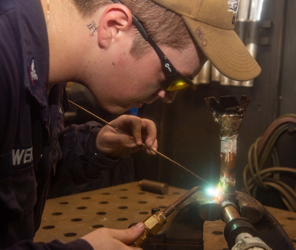 USS Ronald Reagan (CVN 76) Sailors braze pipes in the machine shop