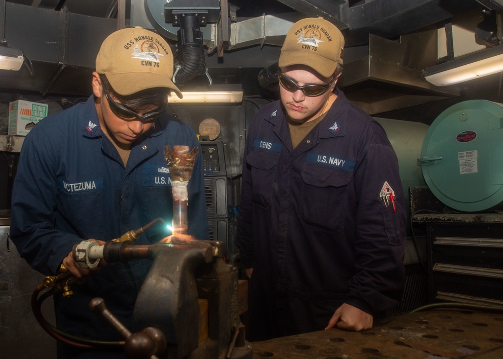 USS Ronald Reagan (CVN 76) Sailors braze pipes in the machine shop
