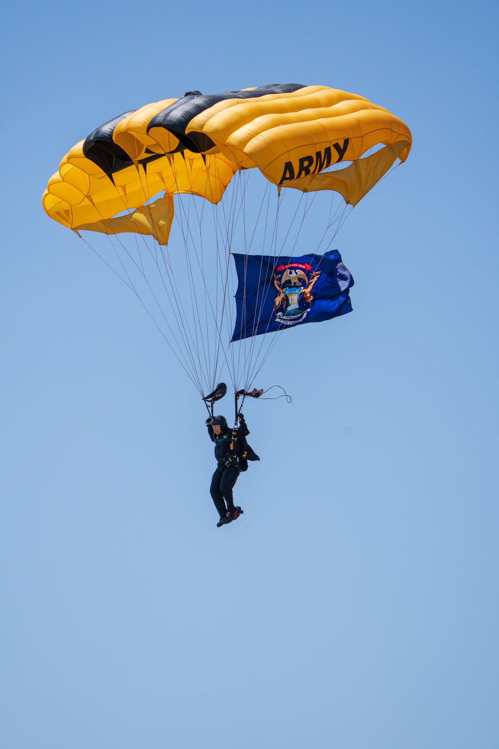 Soldier flies Michigan flag under parachute for demonstration at Selfridge Air National Guard Base