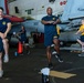 USS Ronald Reagan (CVN-76) Sailors preform physical fitness hangar bay