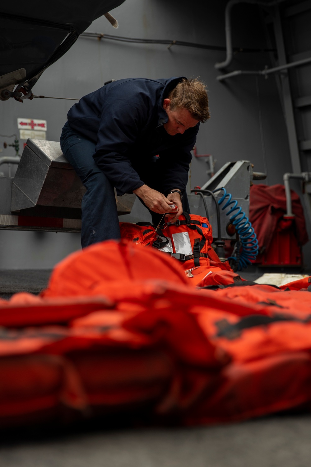 Boatswain’s Mates prepare lifejackets on USS Anchorage