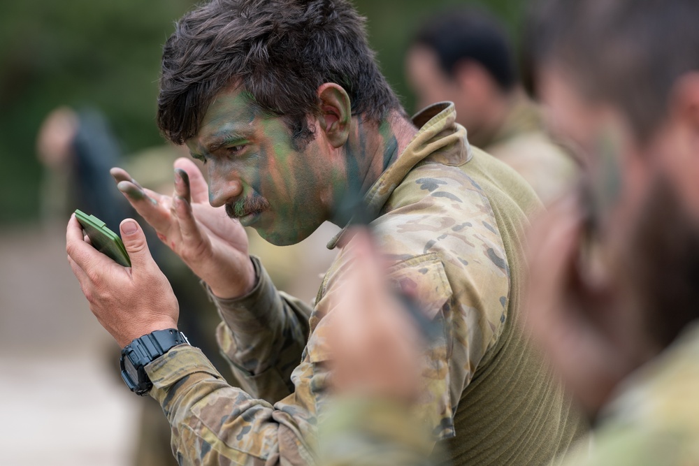 Australian Army Soldier applies camouflage paint