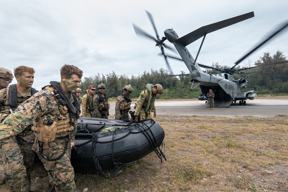 U.S. Marines carry a boat onto a CH-53E helicopter