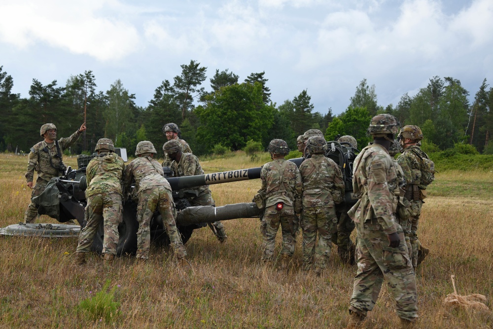Paratroopers assigned to A Battery, 4th Battalion, 319th Field Artillery Regiment, 173rd Airborne Brigade, emplace a M119A3 howitzer at the Grafenwoehr Training Area, Germany