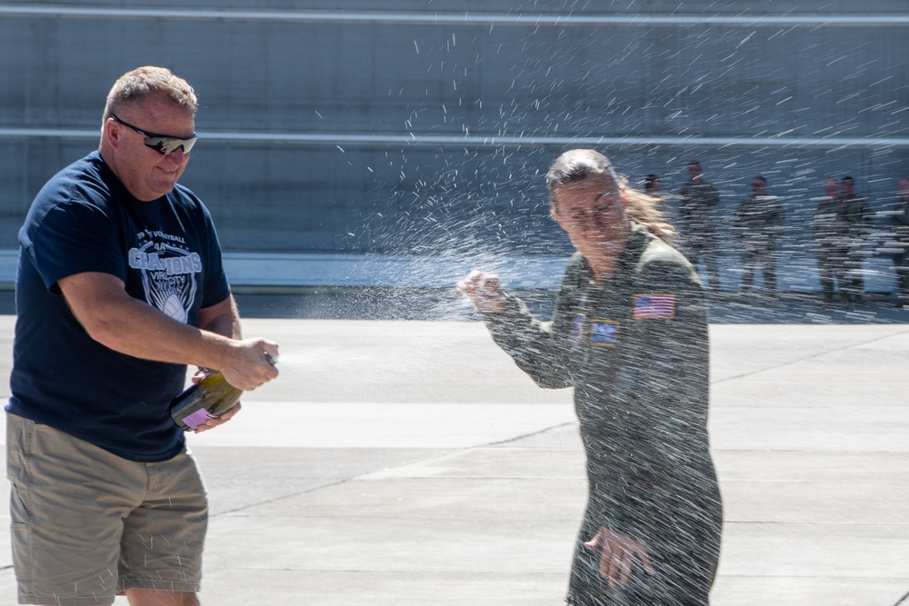 Champagne shower: Senior Master Sgt. Kathy Backlund is sprayed after her final flight "fini-flight" in the C-130 Hercules