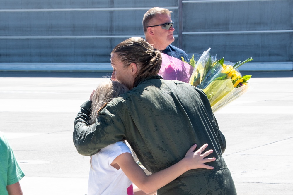 Senior Master Sgt. Kathy Backlund hugs her children after her final flight "fini-flight" in the C-130