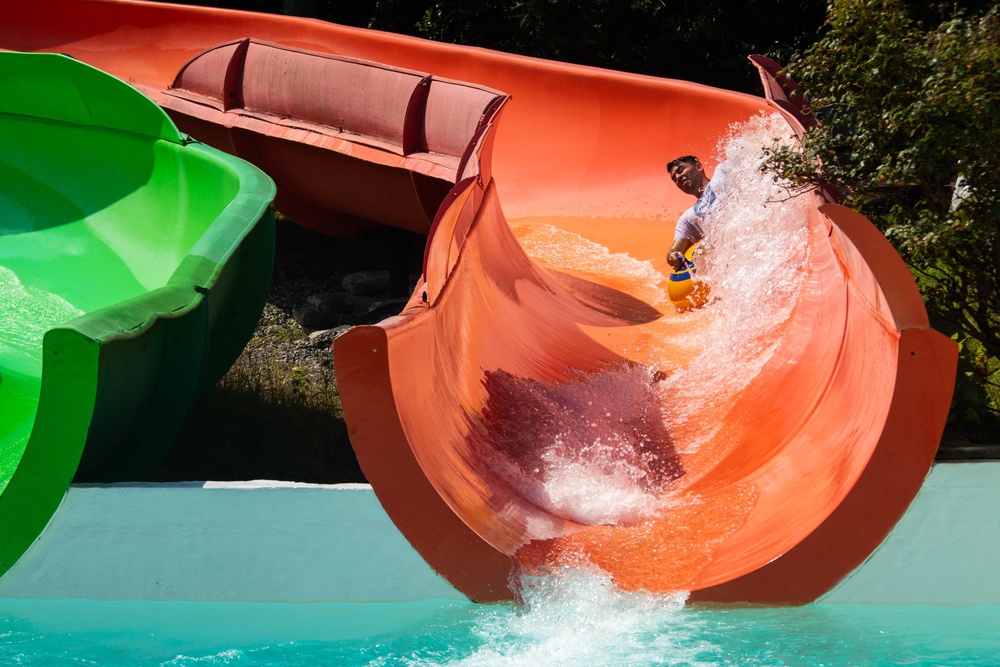 A U.S. Navy Sailor, assigned to the aircraft carrier USS John C. Stennis (CVN 74), slides down a waterslide at the John C. Stennis command picnic, at Oceanbreeze Waterpark, in Virginia Beach, Virginia, July 21, 2022.