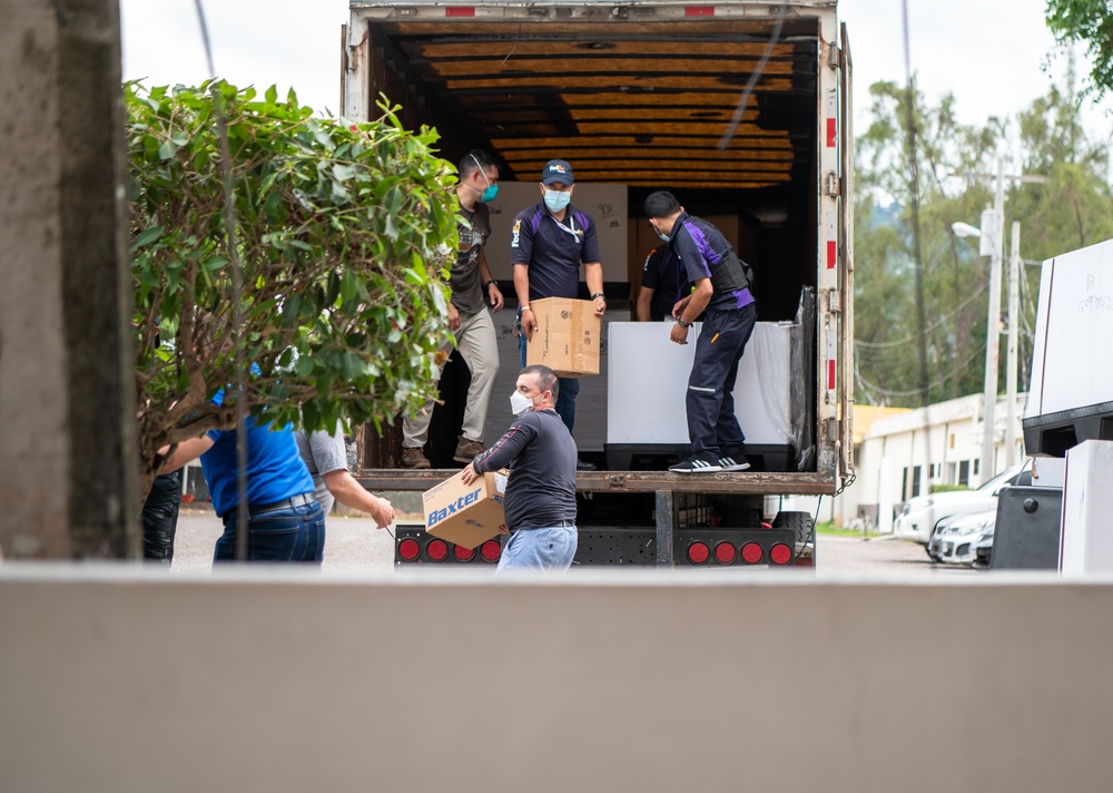 U.S. service members and Hondurans unload medical supplies at Hospitals Escuela, San Felipe