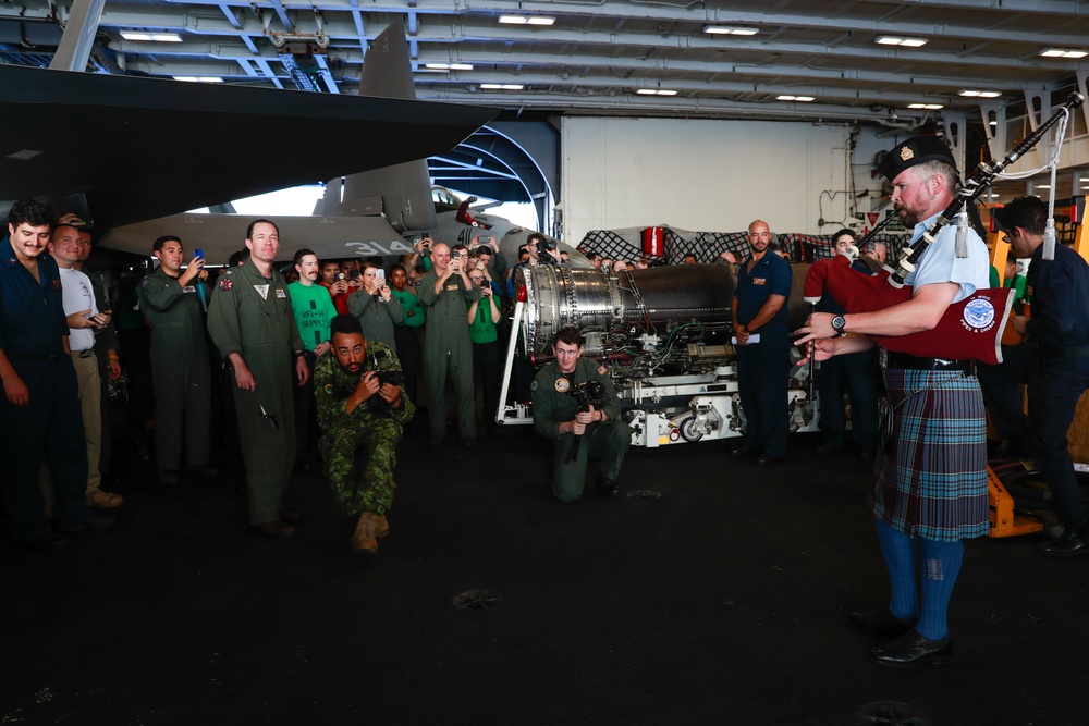 Royal Canadian Air Force Captain plays bagpipes aboard Abraham Lincoln during RIMPAC 2022