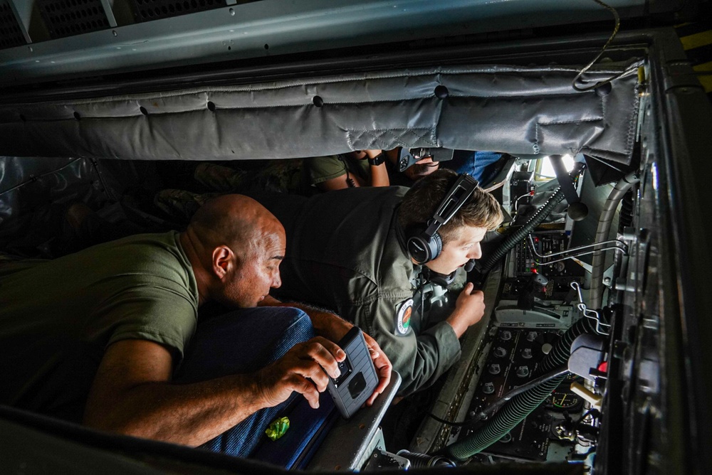 Boom operator and crew chiefs look out boom pod during aerial refueling